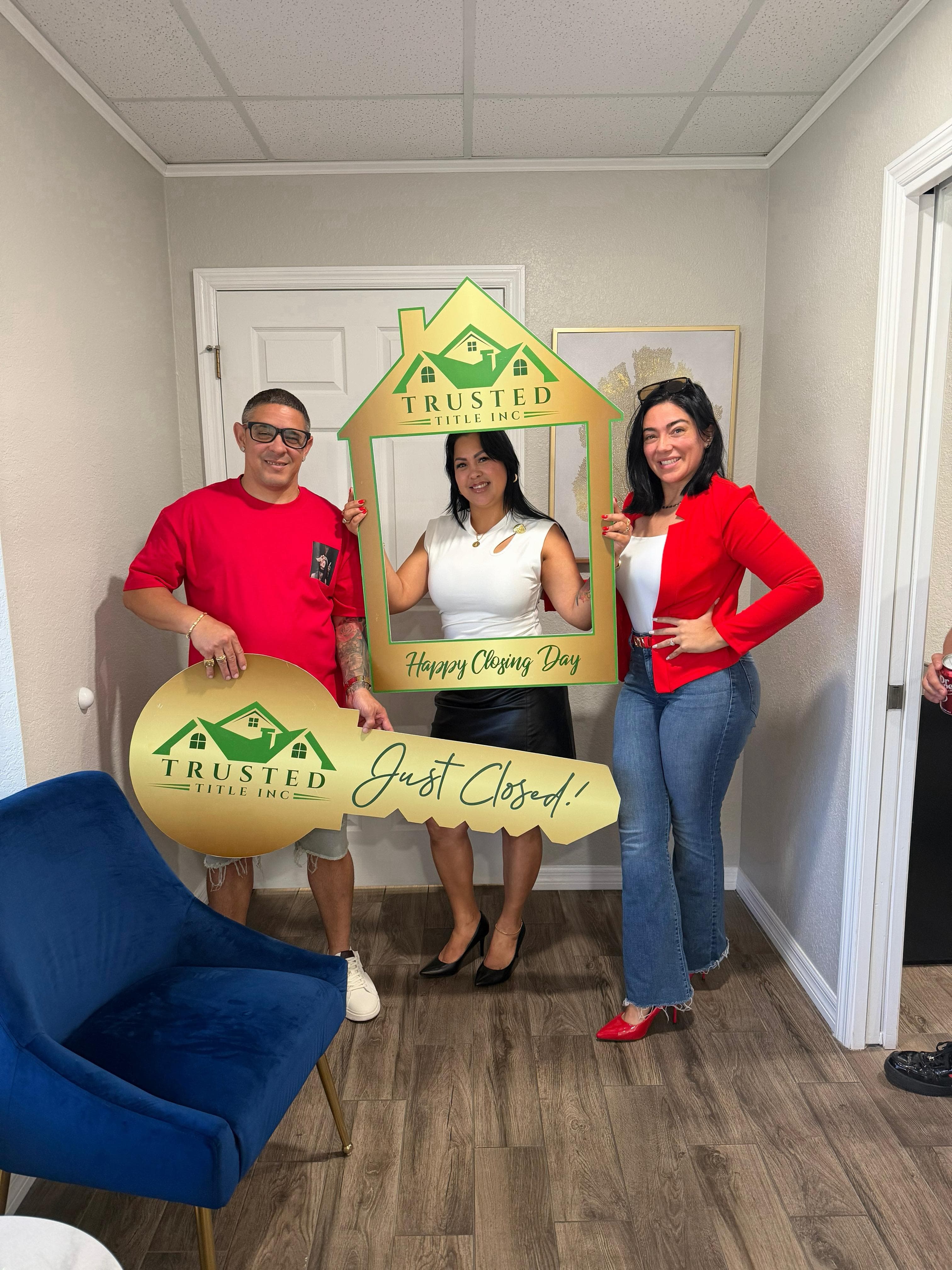 Lazara Diaz with clients holding a large key after a successful closing day